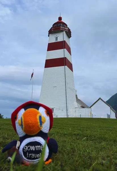 Fluffy at a red and white lighthouse in Norway